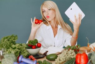 Vlogger promoting healthy eating with fresh vegetables on the table.